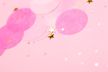 Pink confetti and stars and sparkles on pink background.