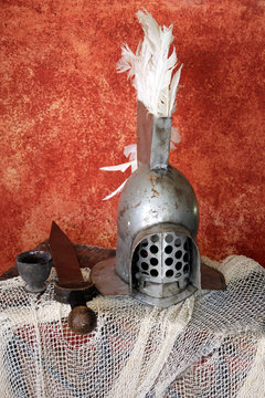 Steel roman gladiator helmet, with a short sword of "gladius", on a net