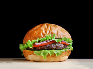 burger isolated on black background. delicious burger with beef, salad and tomatoes