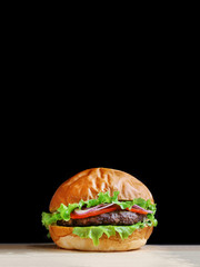 burger isolated on black. burger with salad tomatoes onion and pikles