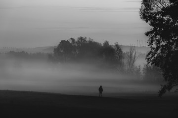 Obraz na płótnie Canvas Man standing alone in darkness and fog