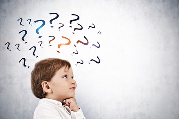 Cute little boy thinking, question marks