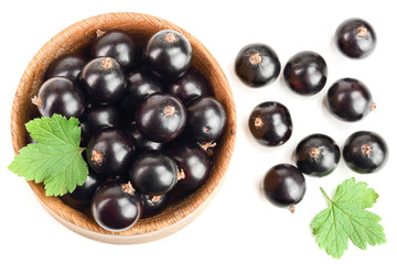 black currant with leaf in wooden bowl isolated on white background. Top view. Flat lay pattern