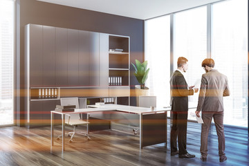 People in dark gray ceo office interior