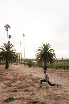 young man with big strides in driveway with palm trees
