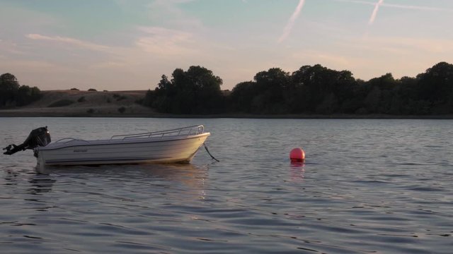 Boat floating next to red beacon