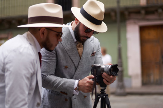 Two stylish men setting up a video camera