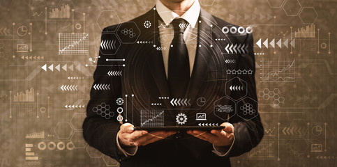 Technology screen with grid with businessman holding a tablet computer on a dark vintage background