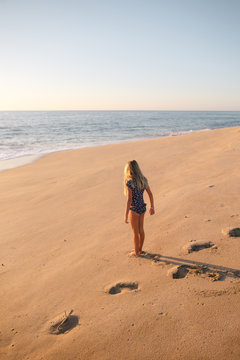 Young girl standing in sand on the beach