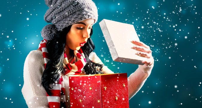 Happy young woman opening a Christmas present box