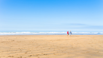 A couple taking a walk along a Cornwall Bude beach