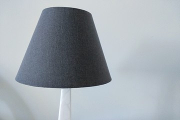 gray lamp with a marble leg against the background of a white wall