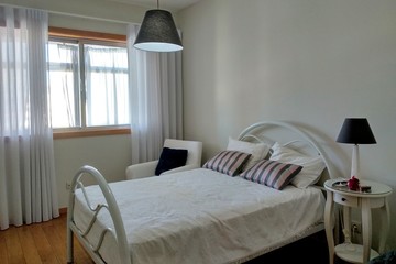 bedroom interior. bright room in white with a bed, an armchair and lamps