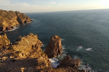 The rocks illuminate the sunlight at sunset. Atlantic Ocean, view from portugal