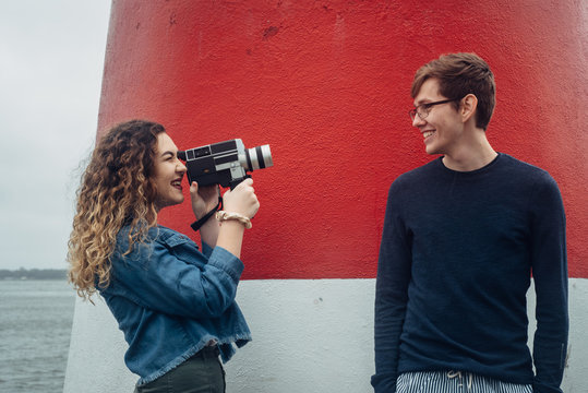 Young Girl Filming Boy With An Old Film Camera