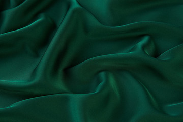 Obraz premium Green silk fabric background, view from above. Smooth elegant green silk or satin luxury cloth texture can use as abstract background with copy space. 