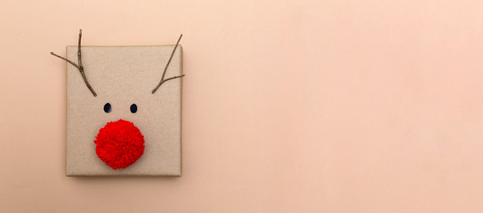 Red nose reindeer gift box on a light brown background © Tierney