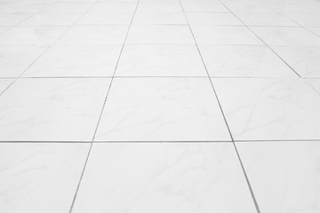 White tile floor background in perspective view. Clean, shiny, symmetry with grid line texture. For decoration in bathroom, kitchen and laundry room. And empty or copy space for product display also.