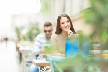 Young beautiful woman in a cafe smiling