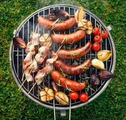 Wall murals Grill / Barbecue Grilled food. Grilled pork sausage, bacon and vegetables on the grill plate, top view, outdoor. Barbecue, bbq