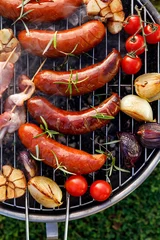 Gardinen Grilled food. Grilled pork sausage, bacon and vegetables on the grill plate, top view, outdoor. Barbecue, bbq © zi3000