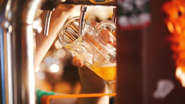 Man pouring draft beer into the glass from the tap