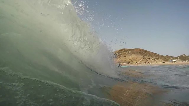 Wave forming in the southwest Portuguese shore, while a surfer is waiting for his oportunity to make it to the line in.