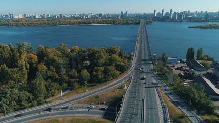 Aerial drone footage. Marathon runners running to bridge from road junction. Static shot