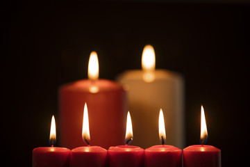 Christmas candles illuminate on dark background