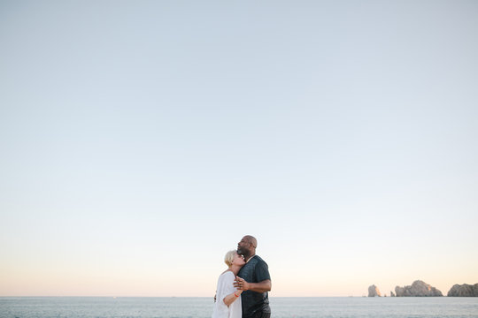 Fun middle aged couple enjoying quality time on the beach at sun