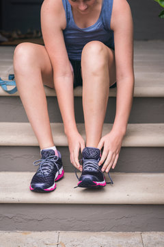 young woman putting on exercise shoes