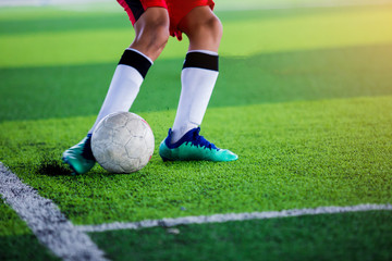 The kid Asian soccer player shoot ball.