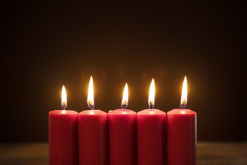 Fototapeta na wymiar Five candles burning in dark background