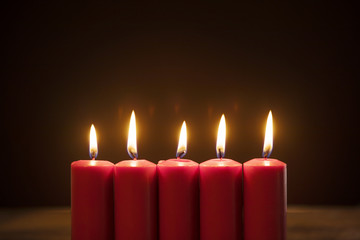 Five candles burning in dark background