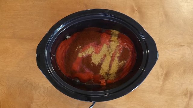 Adding cumin into chili, close up
