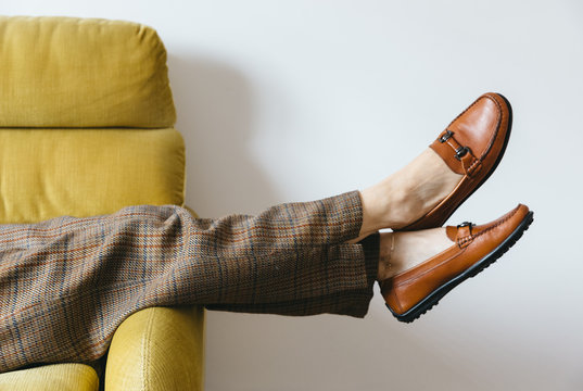 Fototapeta Female wearing wool pants resting on vintage yellow sofa