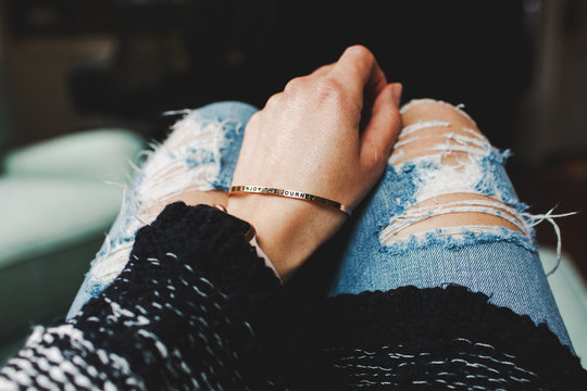 woman wearing a bracelet that reads ""enjoy the journey""
