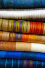 Colorful scarves made of alpaca wool on a shelf in a store in New Zealand
