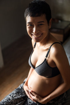 Portrait of a mother to be smiling and looking at the camera