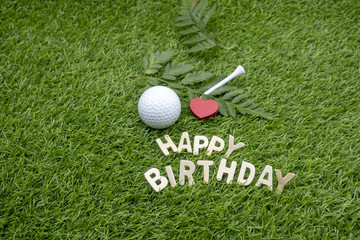Happy Birthday to golfer with golf ball and tee on green grass
