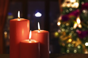 Red candles with blurred Christmas tree