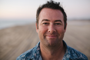Smiling, content man on beach at sunset
