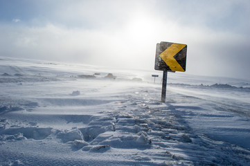 Road sign on a road in Iceland covered in snow after a heavy snow storm