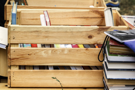 Books in a wooden box are prepared for sale at a street fair. Close-up