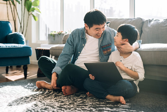 Father and son using laptop at home