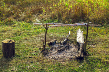 Extinguished bonfire in a field in a green meadow