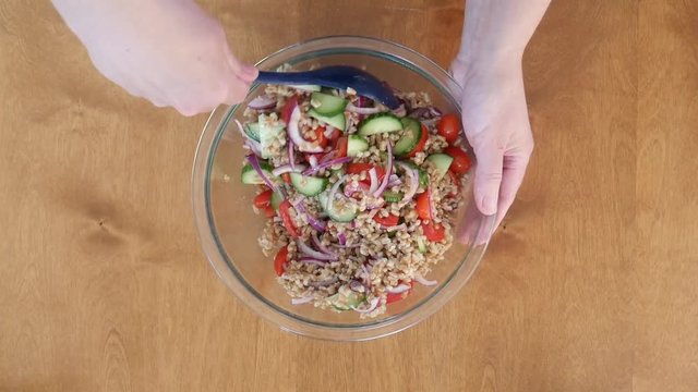 Close up, person mixes summer Farro salad
