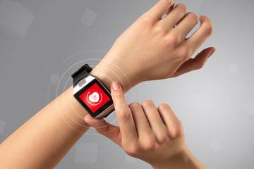 Naked female hand with smartwatch and with heart rate icon on the watch