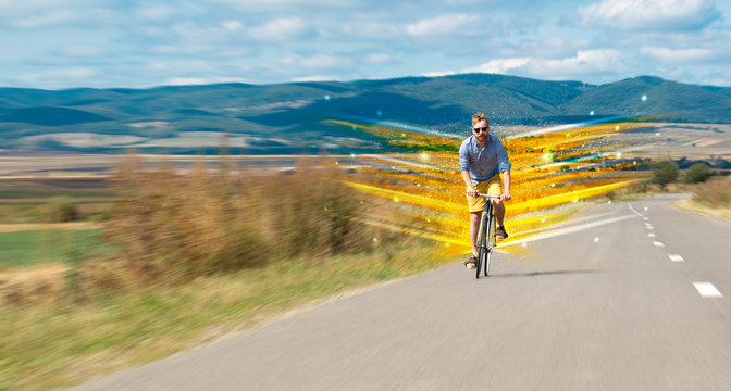 Young riding bicycle in fabulous nature with high speed