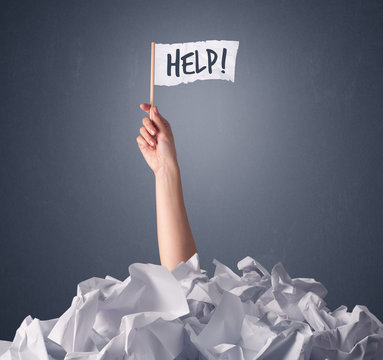 Female Hand Emerging From Crumpled Paper Pile Holding A White Flag With Help Written On It